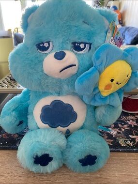Care Bears. Grumpy Bear with a smiling sun flower.